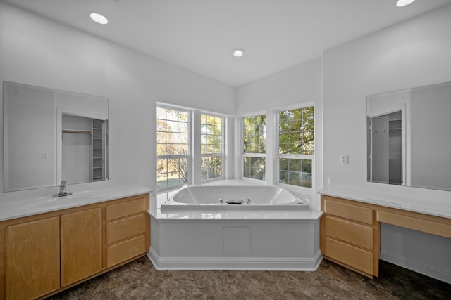 bathroom featuring a washtub and vanity