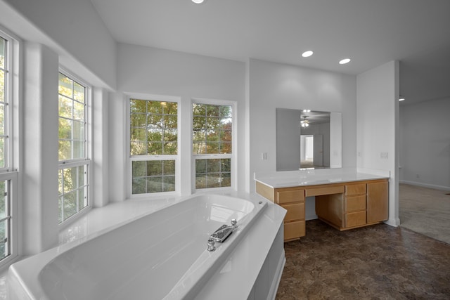 bathroom featuring a bathing tub, ceiling fan, and vanity