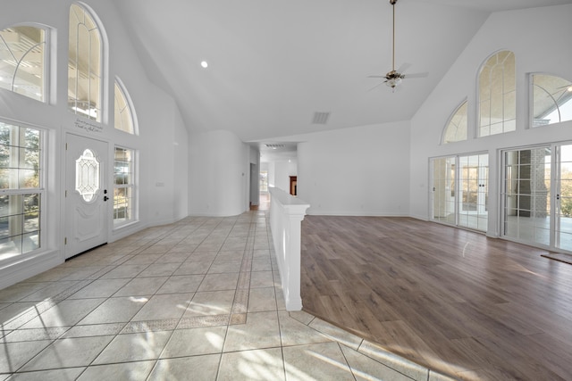 entrance foyer with ceiling fan, high vaulted ceiling, and light hardwood / wood-style floors