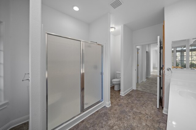 bathroom featuring toilet and walk in shower