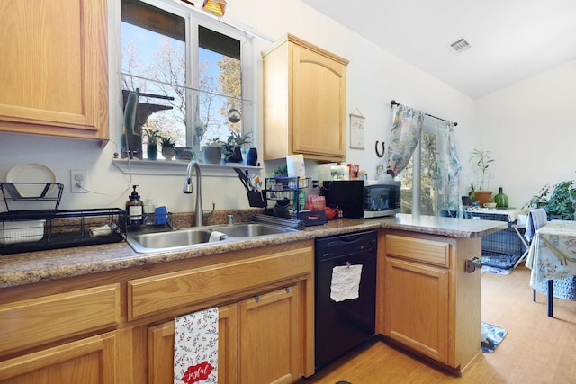 kitchen with kitchen peninsula, light brown cabinetry, sink, black dishwasher, and light hardwood / wood-style floors