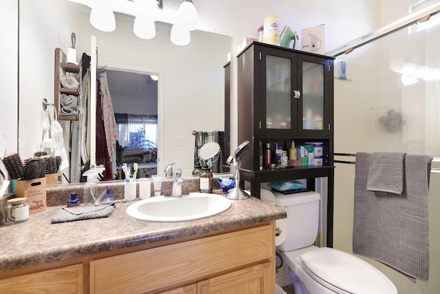 bathroom featuring vanity, an enclosed shower, and toilet