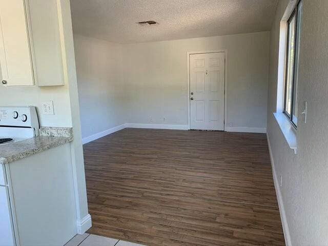 interior space featuring a textured ceiling and dark wood-type flooring