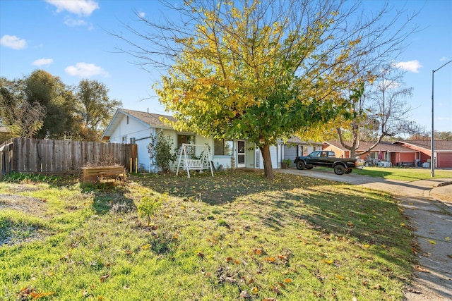 view of property hidden behind natural elements featuring a front yard