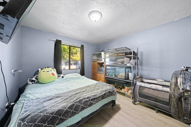 bedroom with wood-type flooring and a textured ceiling