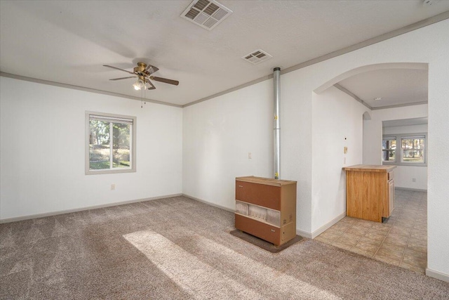 spare room featuring ceiling fan, crown molding, and light colored carpet