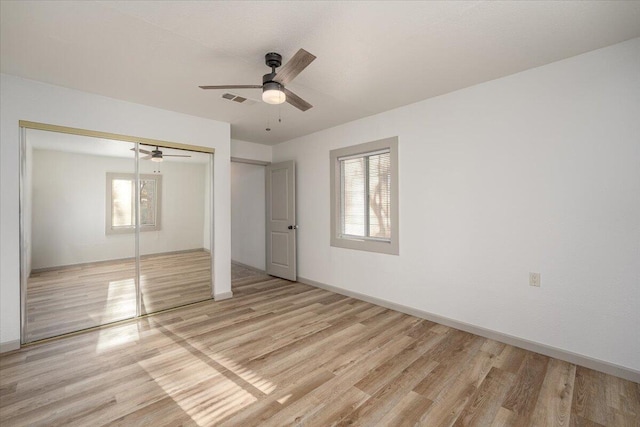 unfurnished bedroom with a closet, light hardwood / wood-style floors, and ceiling fan