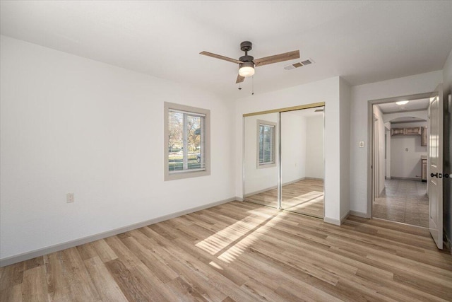 unfurnished bedroom with light wood-type flooring, a closet, and ceiling fan