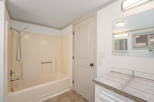 bathroom with a textured ceiling and bathtub / shower combination