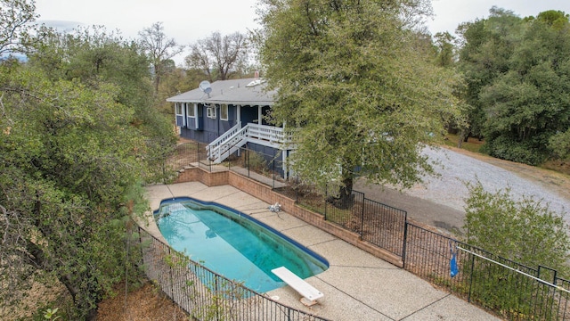 view of pool with a diving board and a patio