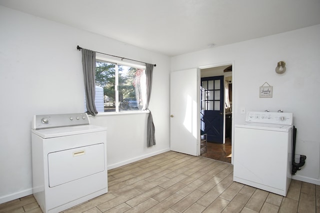 washroom with washing machine and dryer and light hardwood / wood-style flooring