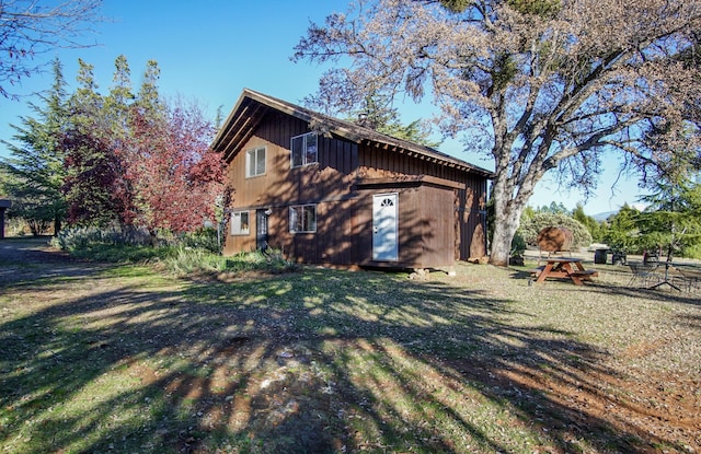 view of home's exterior with a lawn and an outbuilding