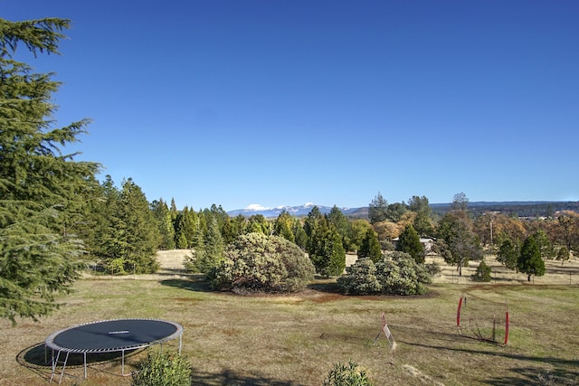 view of yard with a mountain view, a rural view, and a trampoline