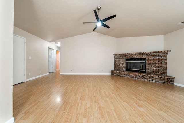 unfurnished living room featuring ceiling fan, light hardwood / wood-style flooring, vaulted ceiling, and a brick fireplace