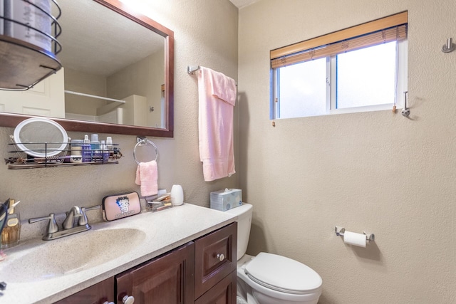 bathroom featuring vanity, toilet, and a shower