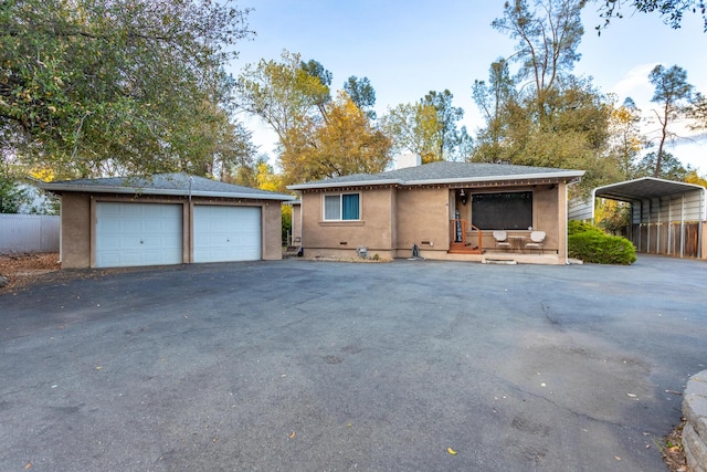 ranch-style home with a garage, an outdoor structure, and a carport