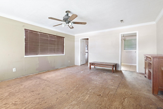 empty room featuring ceiling fan and crown molding