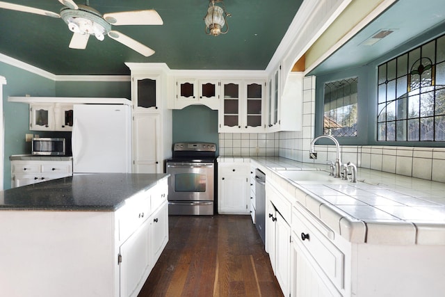 kitchen with white cabinetry, decorative backsplash, sink, dark hardwood / wood-style flooring, and stainless steel appliances