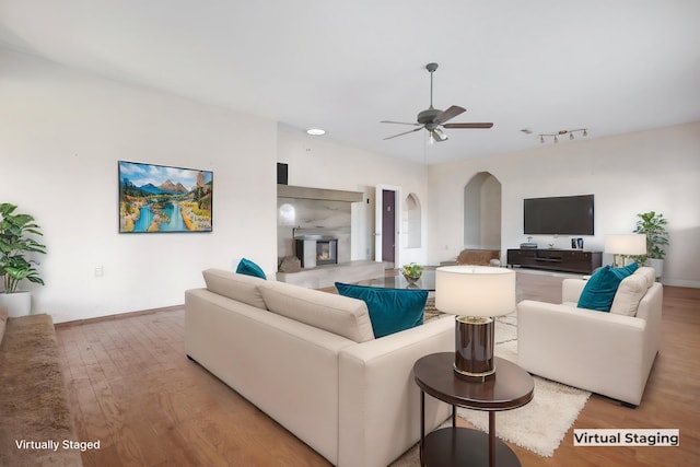 living room with light wood-type flooring, ceiling fan, and track lighting