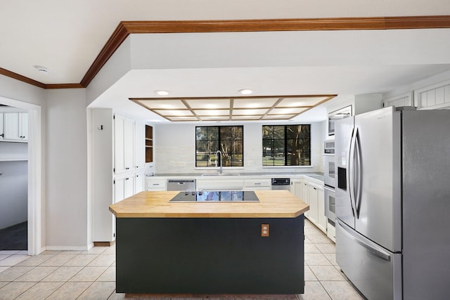 kitchen with a center island, wooden counters, sink, white cabinetry, and stainless steel appliances