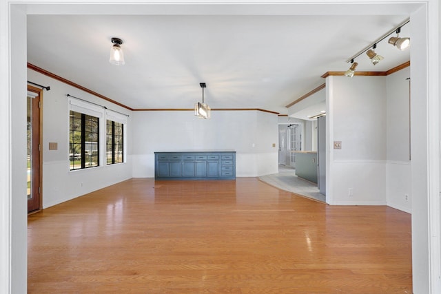 unfurnished living room with ornamental molding and light wood-type flooring