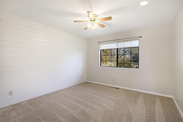 carpeted spare room featuring ceiling fan