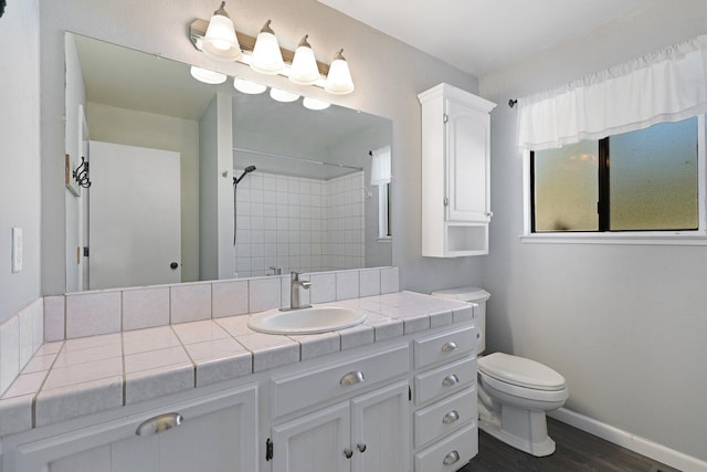 bathroom featuring walk in shower, vanity, wood-type flooring, and toilet