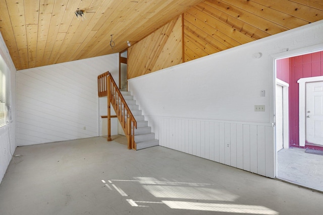 unfurnished living room featuring wooden walls, concrete floors, lofted ceiling, and wooden ceiling