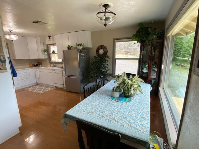 dining space with hardwood / wood-style flooring, sink, and a wealth of natural light