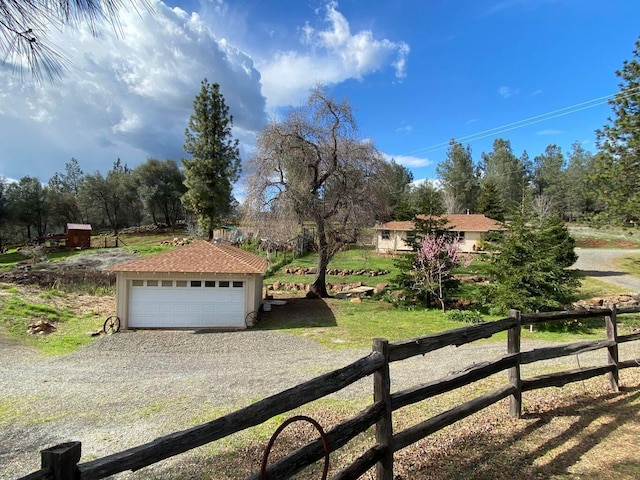 view of yard with a rural view, a garage, and an outdoor structure