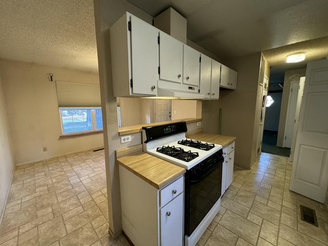 kitchen featuring white cabinetry, a textured ceiling, and white gas range oven