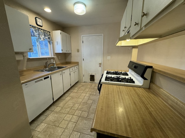 kitchen with white appliances, white cabinetry, and sink