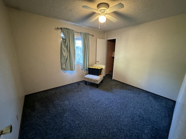 carpeted empty room with a textured ceiling and ceiling fan