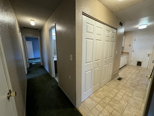 corridor featuring a textured ceiling