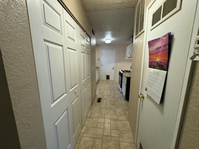 corridor featuring a textured ceiling