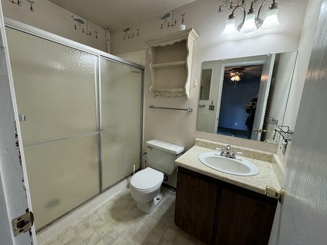 bathroom with vanity, toilet, an enclosed shower, and ceiling fan