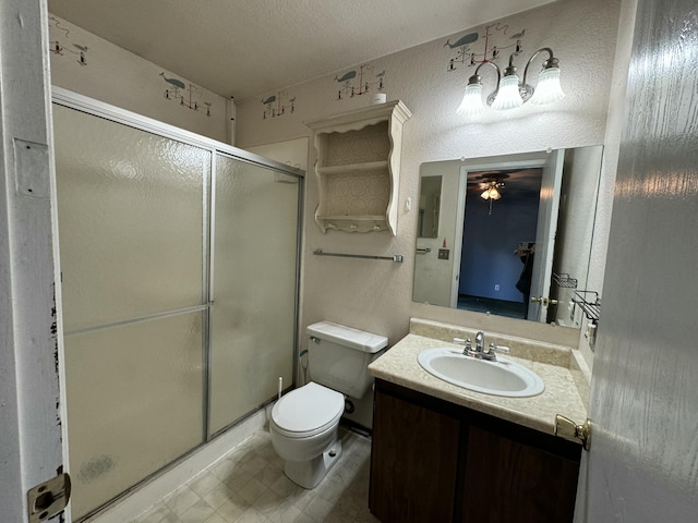 bathroom with ceiling fan, walk in shower, a textured ceiling, toilet, and vanity