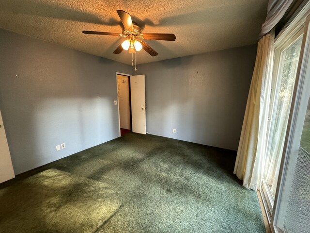 carpeted spare room with ceiling fan and a textured ceiling