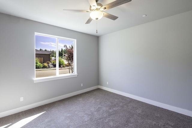 carpeted spare room featuring ceiling fan