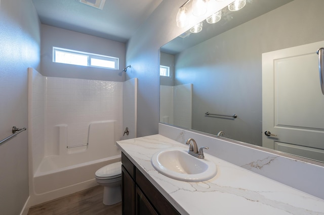 full bathroom with vanity, toilet, wood-type flooring, and tub / shower combination