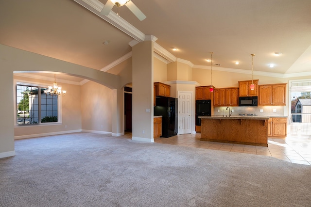 kitchen featuring tasteful backsplash, decorative light fixtures, light colored carpet, a kitchen island with sink, and black appliances