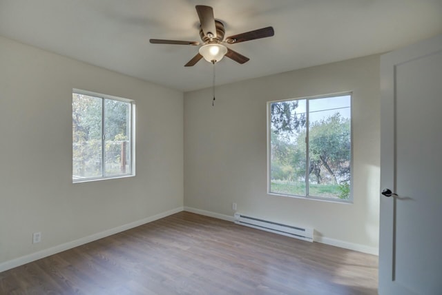 empty room featuring ceiling fan, light wood-type flooring, and a baseboard heating unit