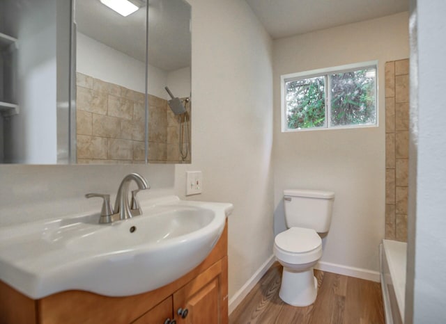 bathroom with toilet, vanity, and hardwood / wood-style flooring