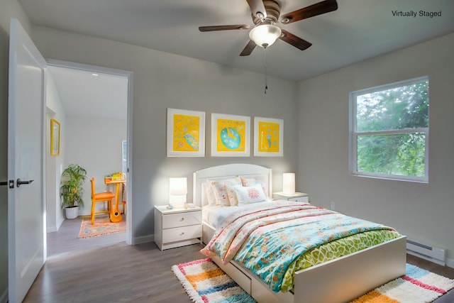 bedroom featuring dark hardwood / wood-style flooring, a baseboard radiator, and ceiling fan