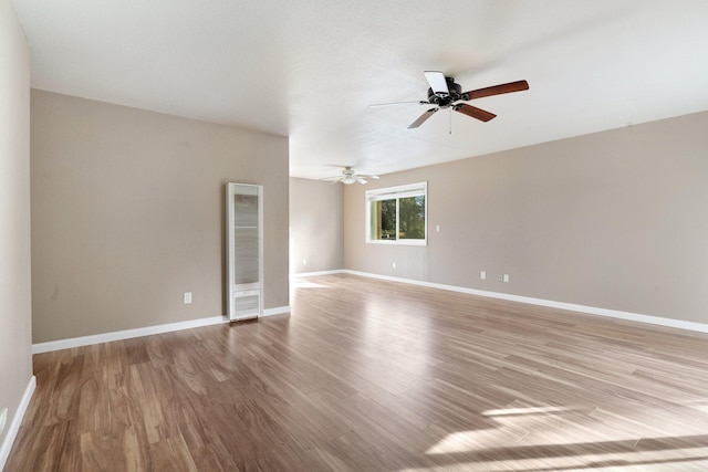 empty room with ceiling fan and light hardwood / wood-style flooring