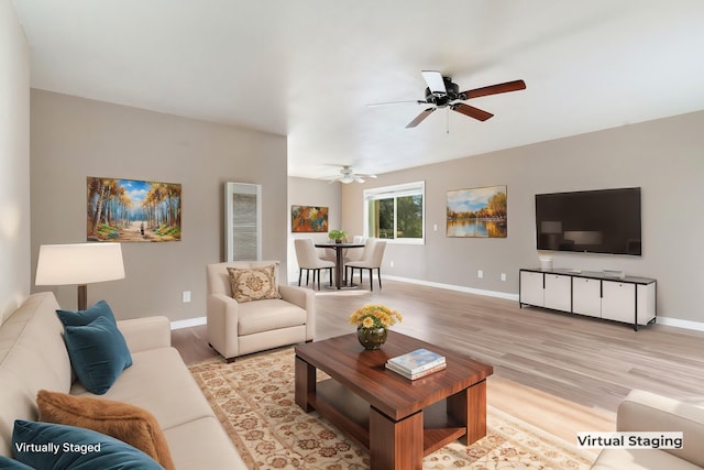 living room featuring ceiling fan and light hardwood / wood-style flooring