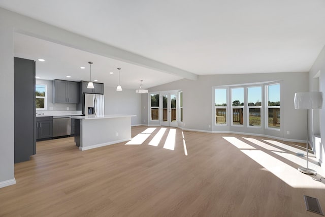 unfurnished living room with vaulted ceiling with beams and light hardwood / wood-style flooring