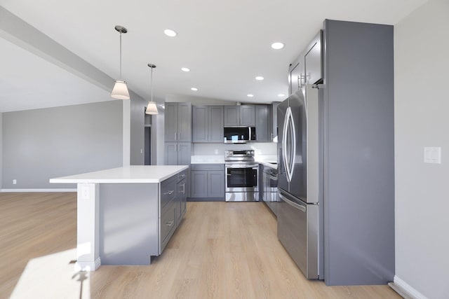 kitchen with pendant lighting, gray cabinetry, lofted ceiling, light hardwood / wood-style floors, and stainless steel appliances