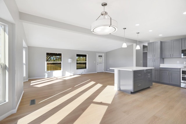 kitchen with light wood-type flooring, a center island, hanging light fixtures, and gray cabinetry