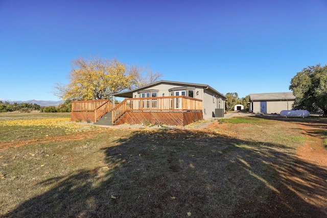 exterior space featuring central AC, a lawn, an outdoor structure, and a wooden deck